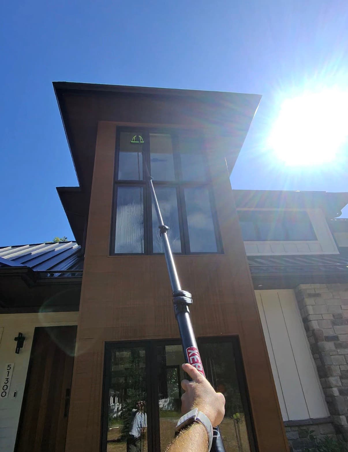 water-fed pole on a modern home, sun overhead