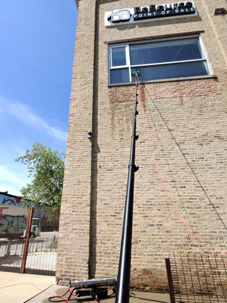 water-fed pole reaching a second-story commercial window