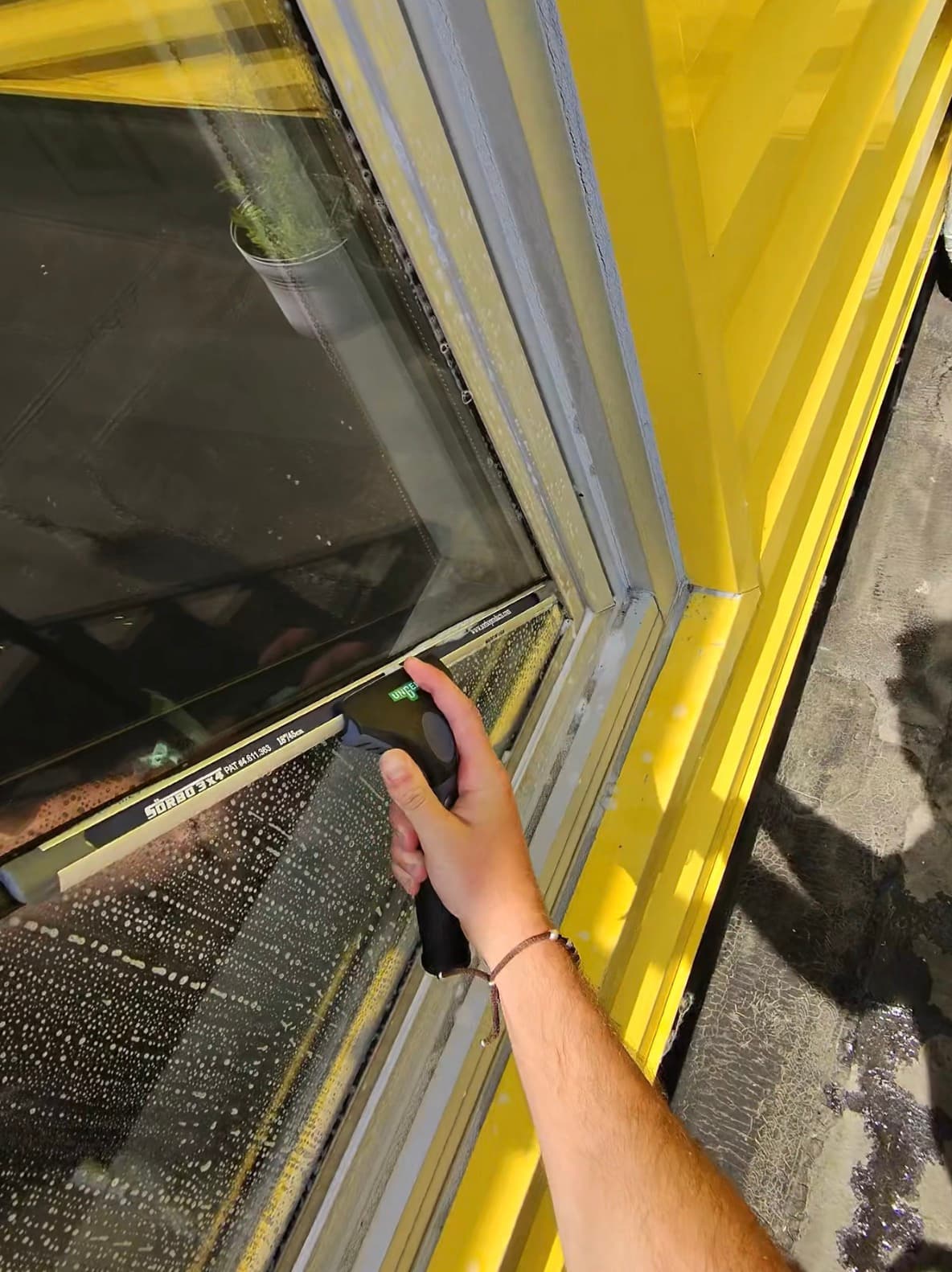 squeegee detail by hand, water sheeting off the glass